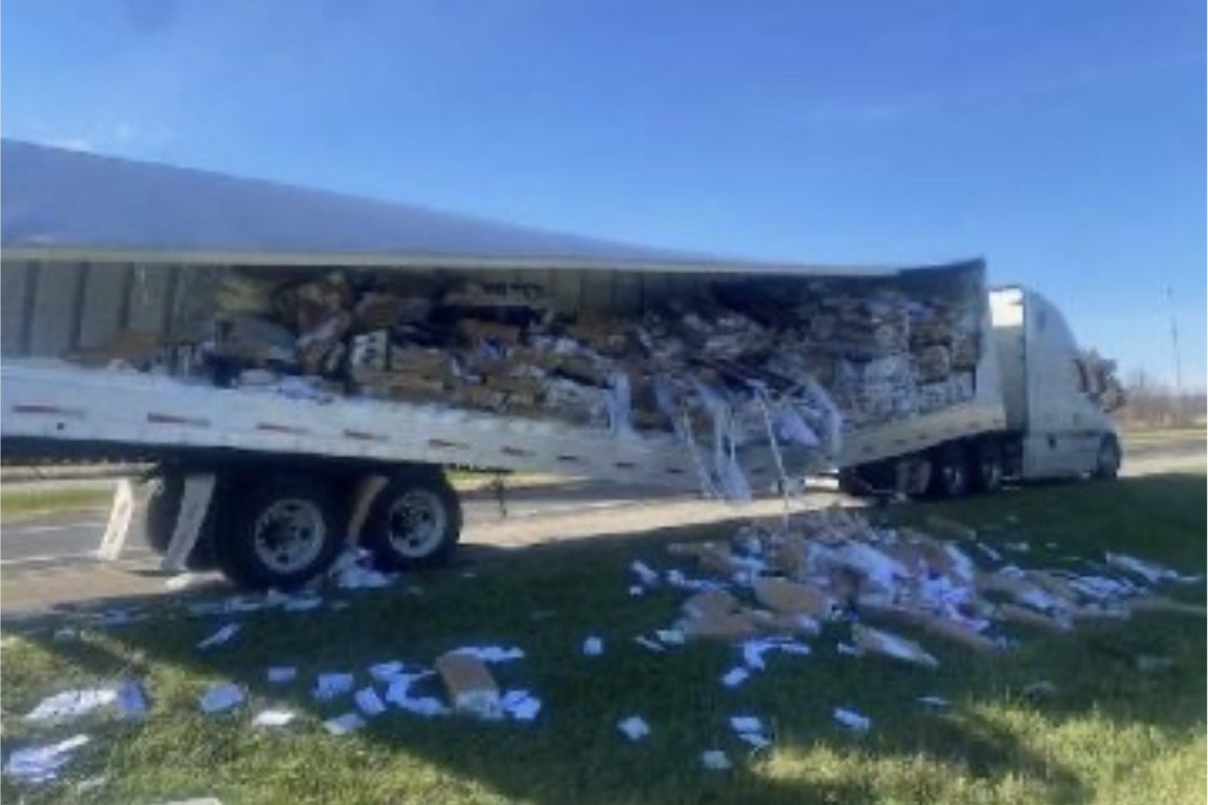 image of overturned truck with direct mail pieces spilling onto the highway