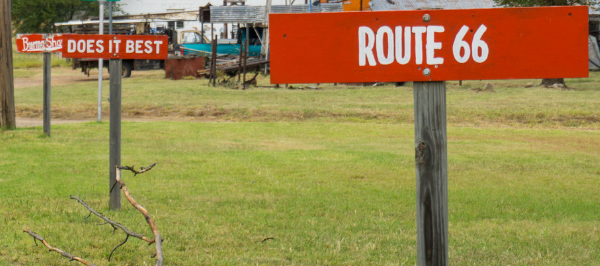 Three red signs along the road say "Burma Shave," "Does It Best," and "Route 66" in white lettering.