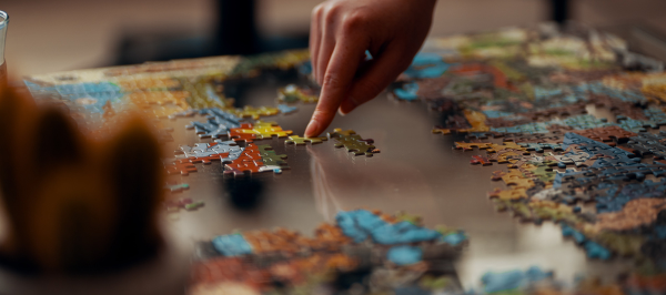 A hand slides a puzzle piece into place