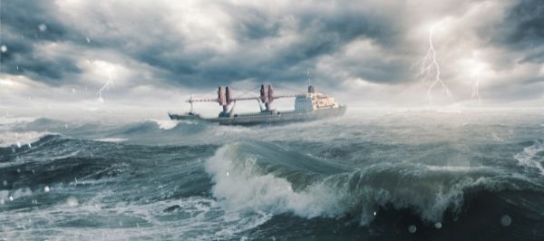 A large container ship navigates stormy seas.